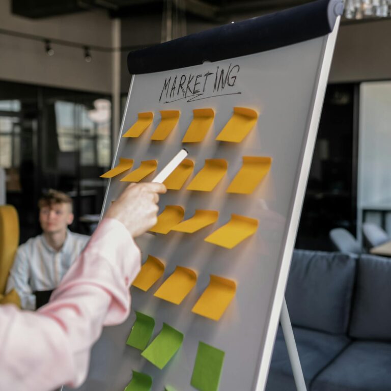 
A Person Pointing at a Whiteboard while Holding a Pen