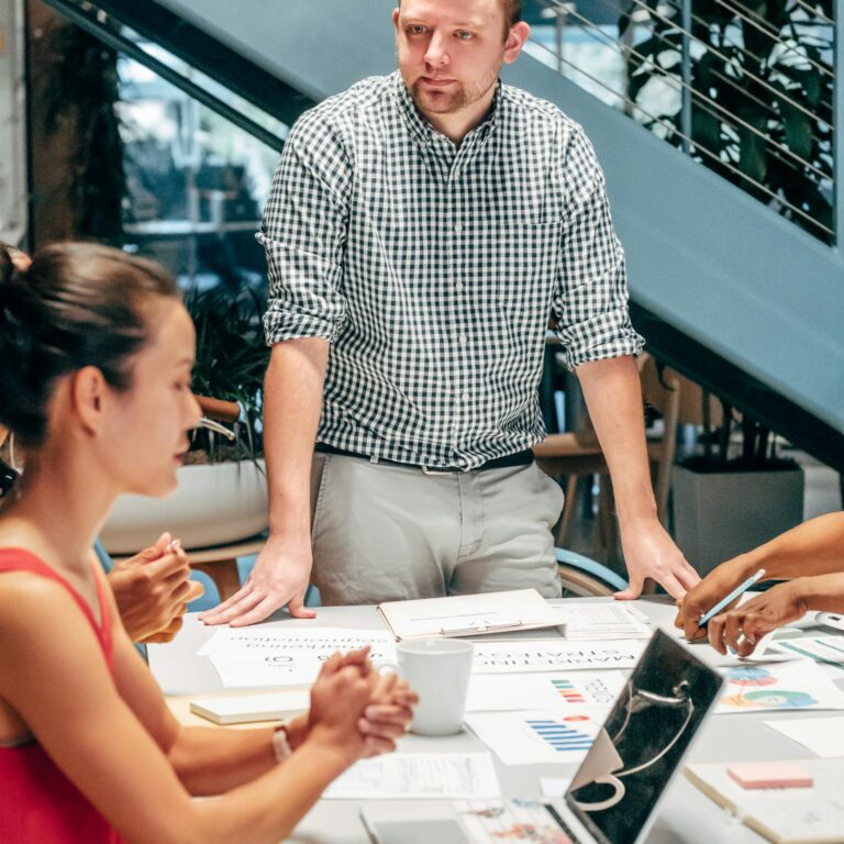 Man in Black and White Checkered Button Up Shirt Sitting Beside Woman in Red Sleeveless Top